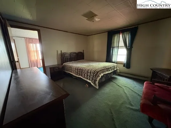 a bedroom with a bed dresser and window