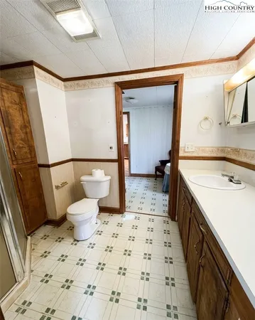 a bathroom with a sink a toilet and a large mirror