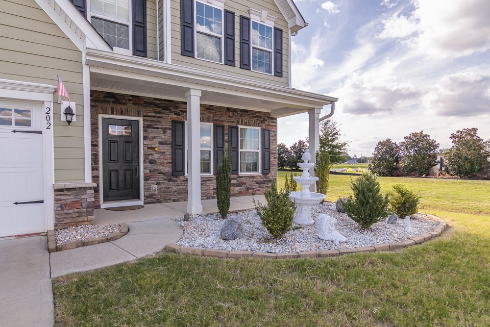 202 Bronson Ridge Anderson, SC 29621 - Photo 5 of 38 This residence features a charming front entrance with a decorative fountain and landscaping.