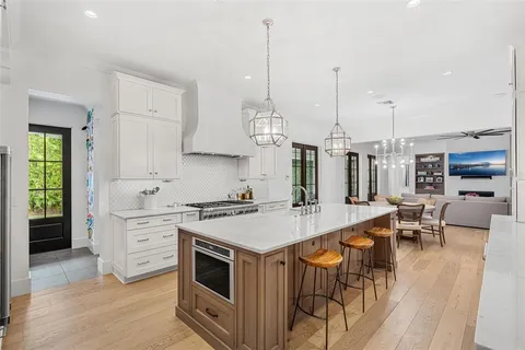 a open kitchen with stainless steel appliances granite countertop a stove and chairs