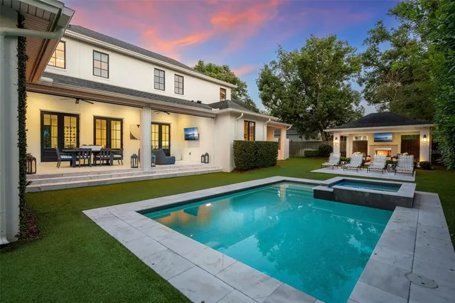 a view of house with swimming pool and outdoor seating