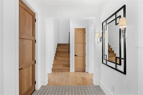 a view of a hallway with wooden floor and entryway