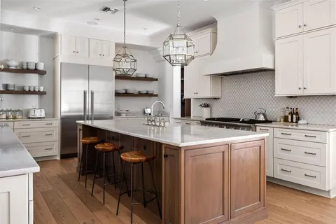 a kitchen with white cabinets stainless steel appliances and kitchen island