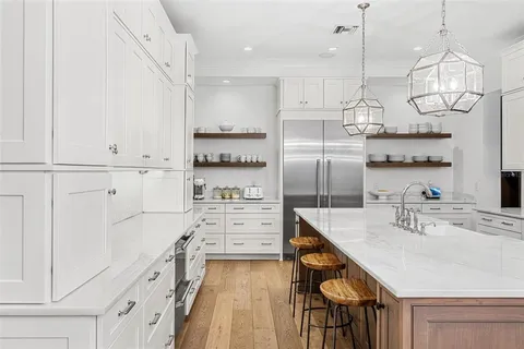a kitchen with kitchen island white cabinets and stainless steel appliances