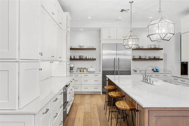 a kitchen with kitchen island white cabinets and stainless steel appliances