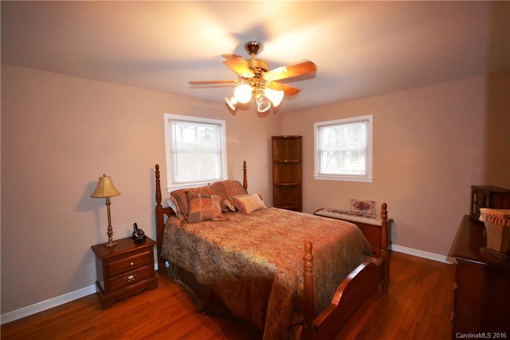 445 Loop Road Hendersonville, NC 28792 - Photo 4 of 13 a bedroom with a bed and a chandelier