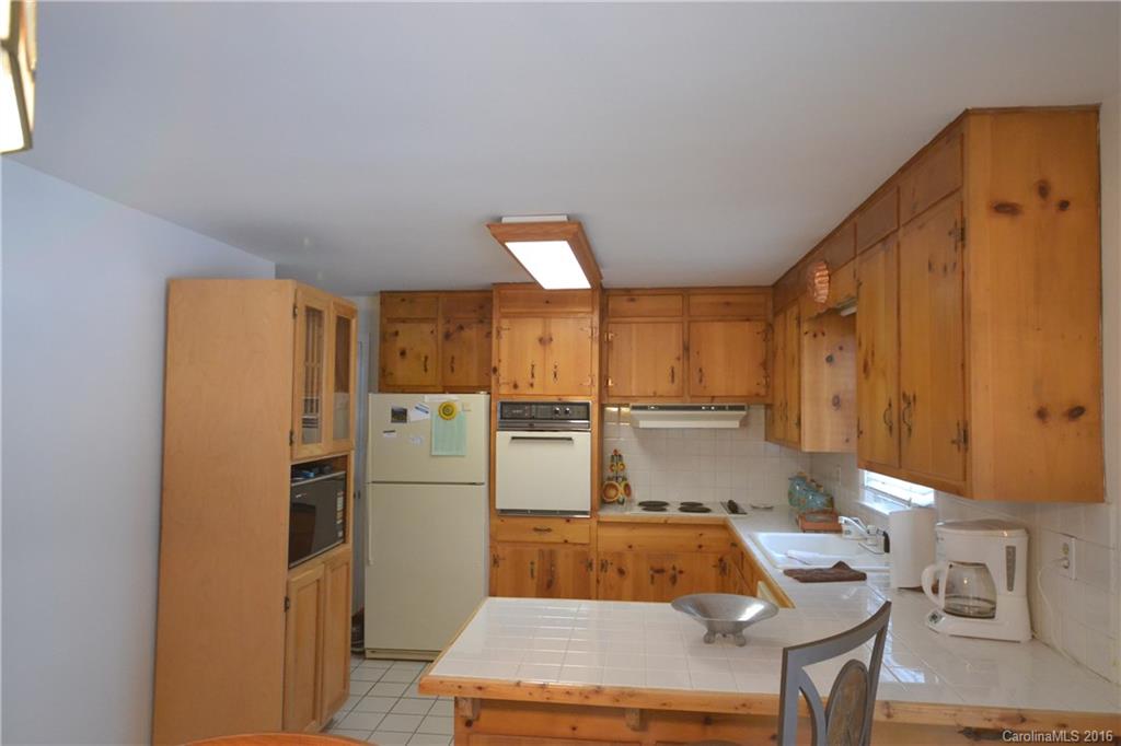 445 Loop Road Hendersonville, NC 28792 - Photo 7 of 13 a kitchen with a refrigerator a stove and a dining table