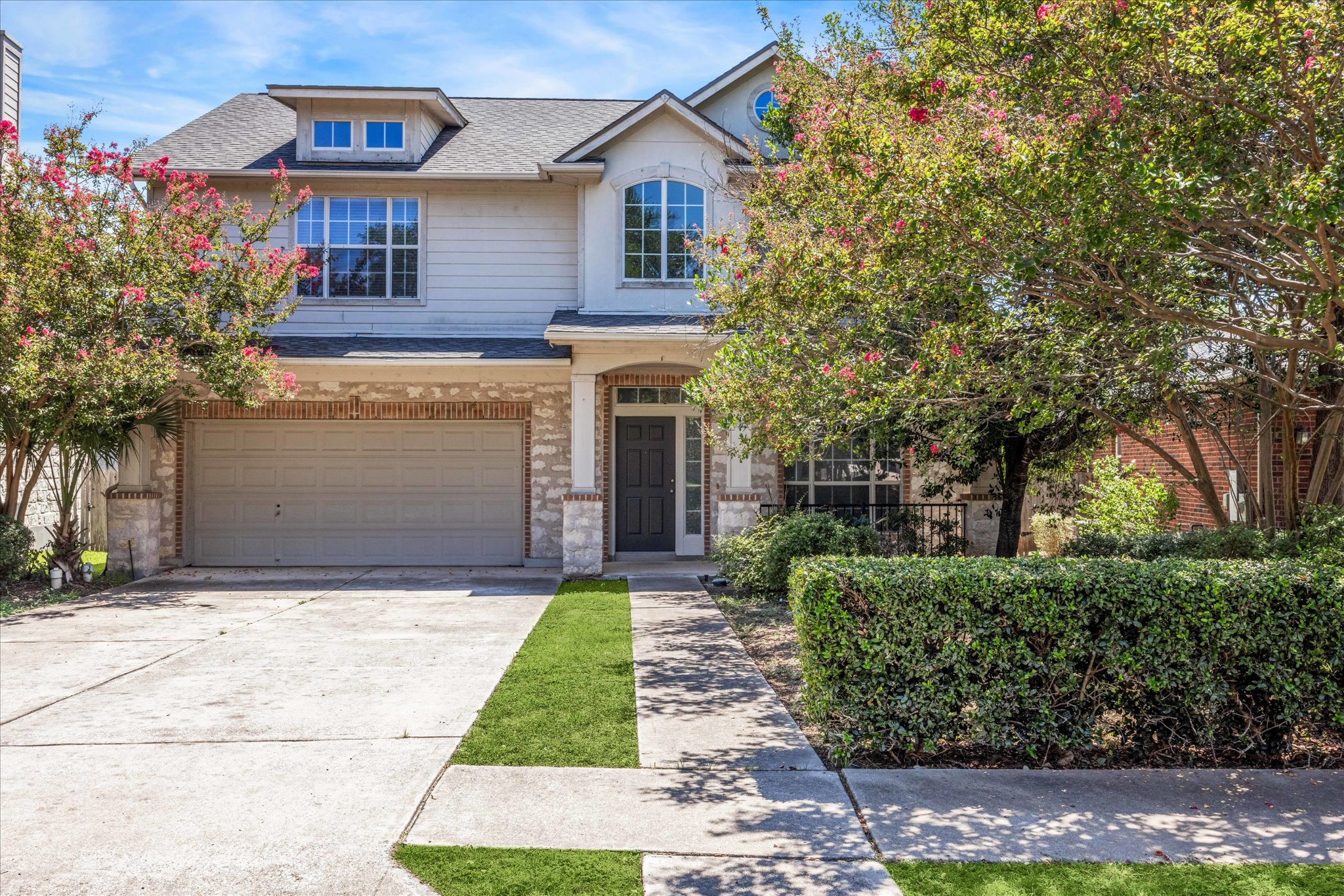 a front view of a house with a garden