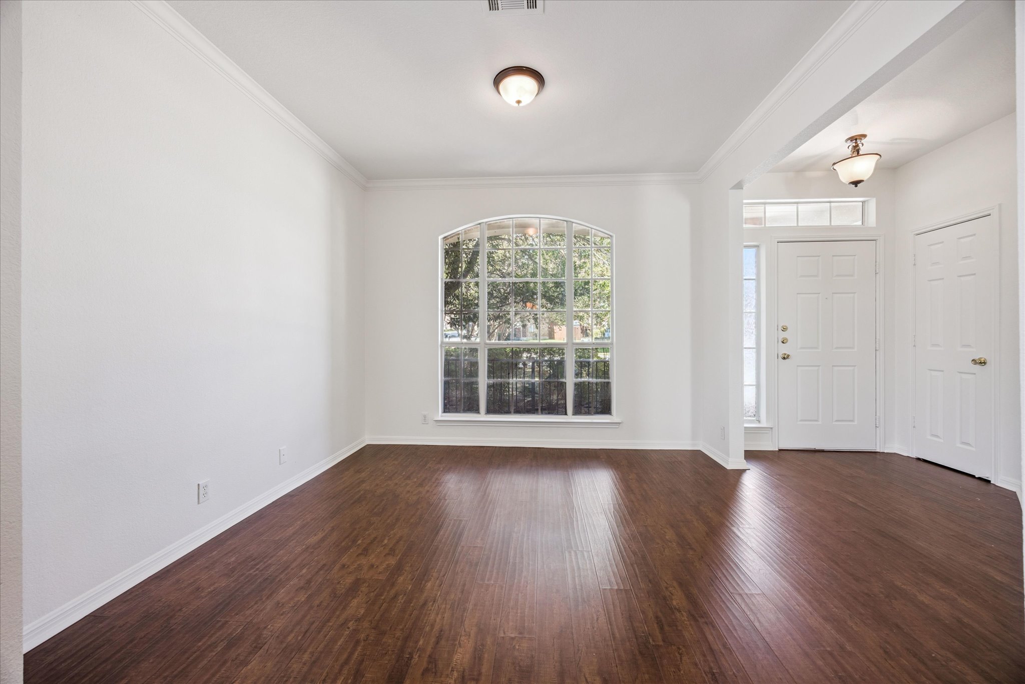 111 North Field Street Round Rock, TX 78681 - Photo 9 of 40 an empty room with wooden floor and windows