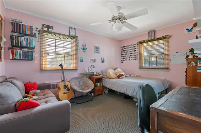 a bedroom with bed couch and window