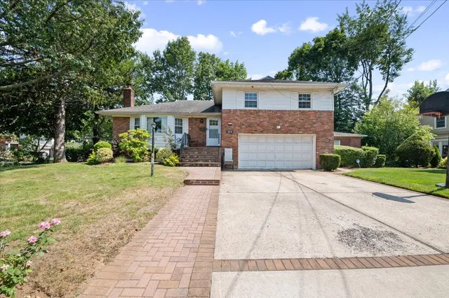 a front view of a house with a yard and potted plants