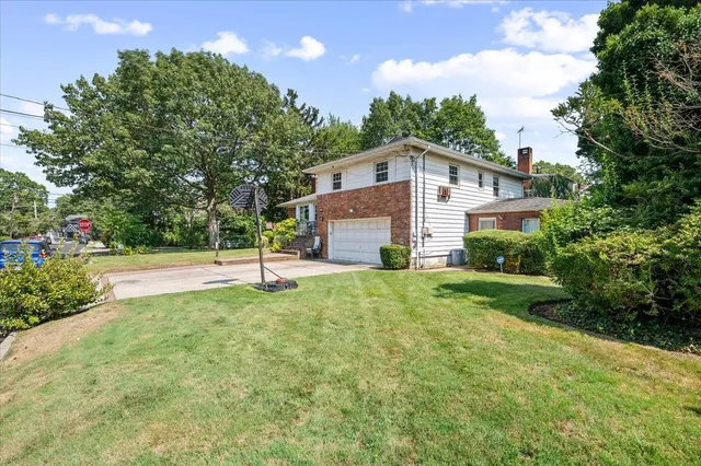 a front view of a house with yard and tree s