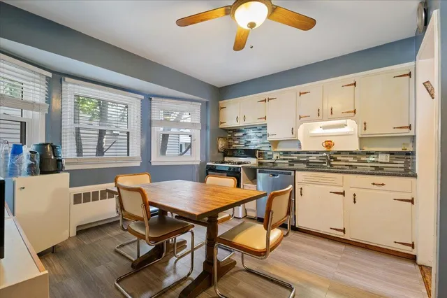 a kitchen with a dining table chairs and white cabinets