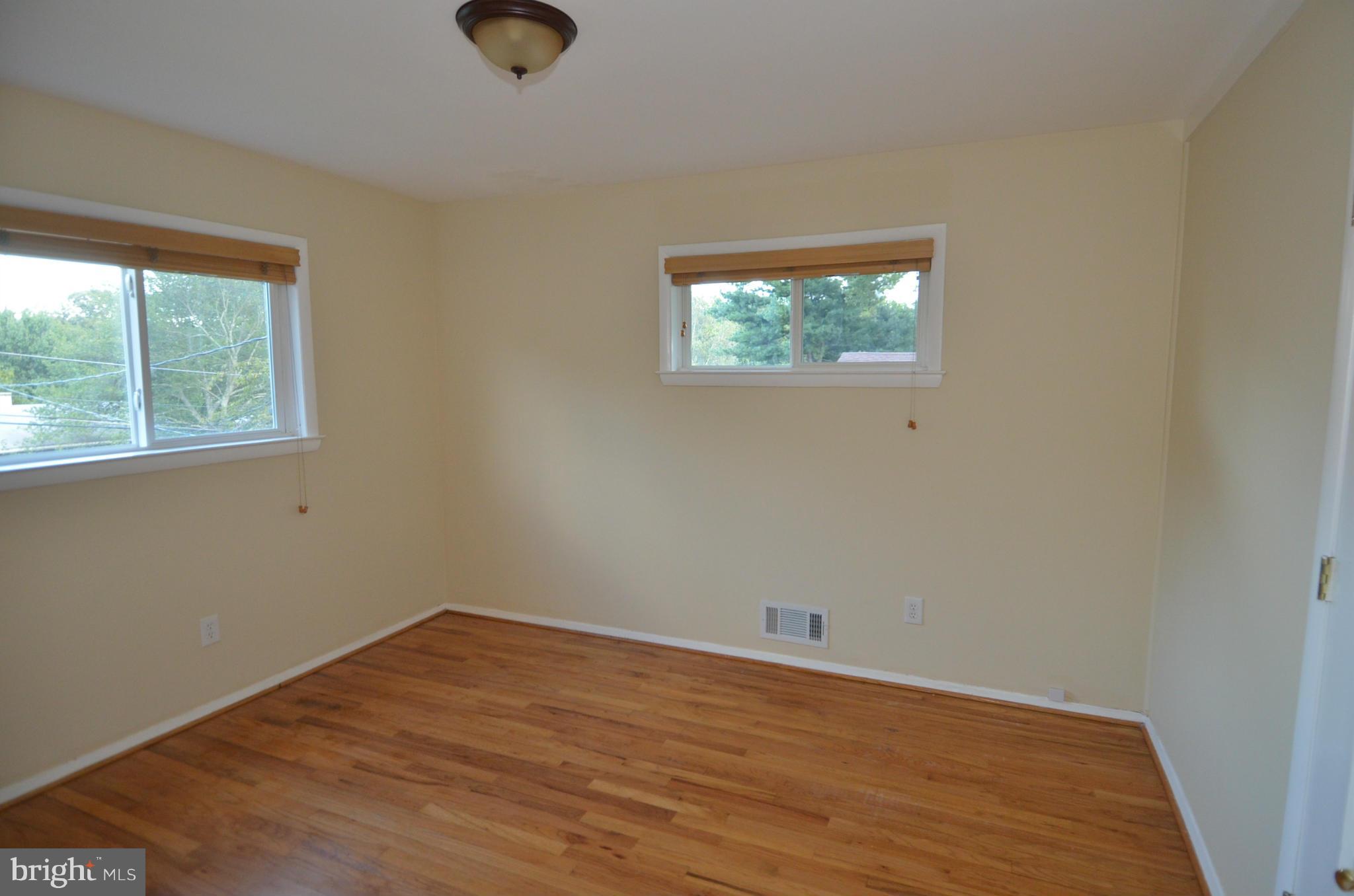 11806 Selfridge Road Silver Spring, MD 20906 - Photo 18 of 25 an empty room with wooden floor and windows