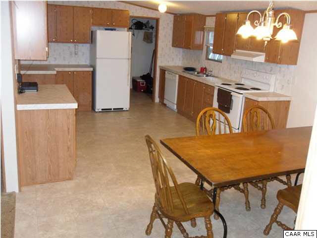 1733 Mutton Hollow Road Stanardsville, VA 22973 - Photo 4 of 12 a room with a table chairs and a refrigerator