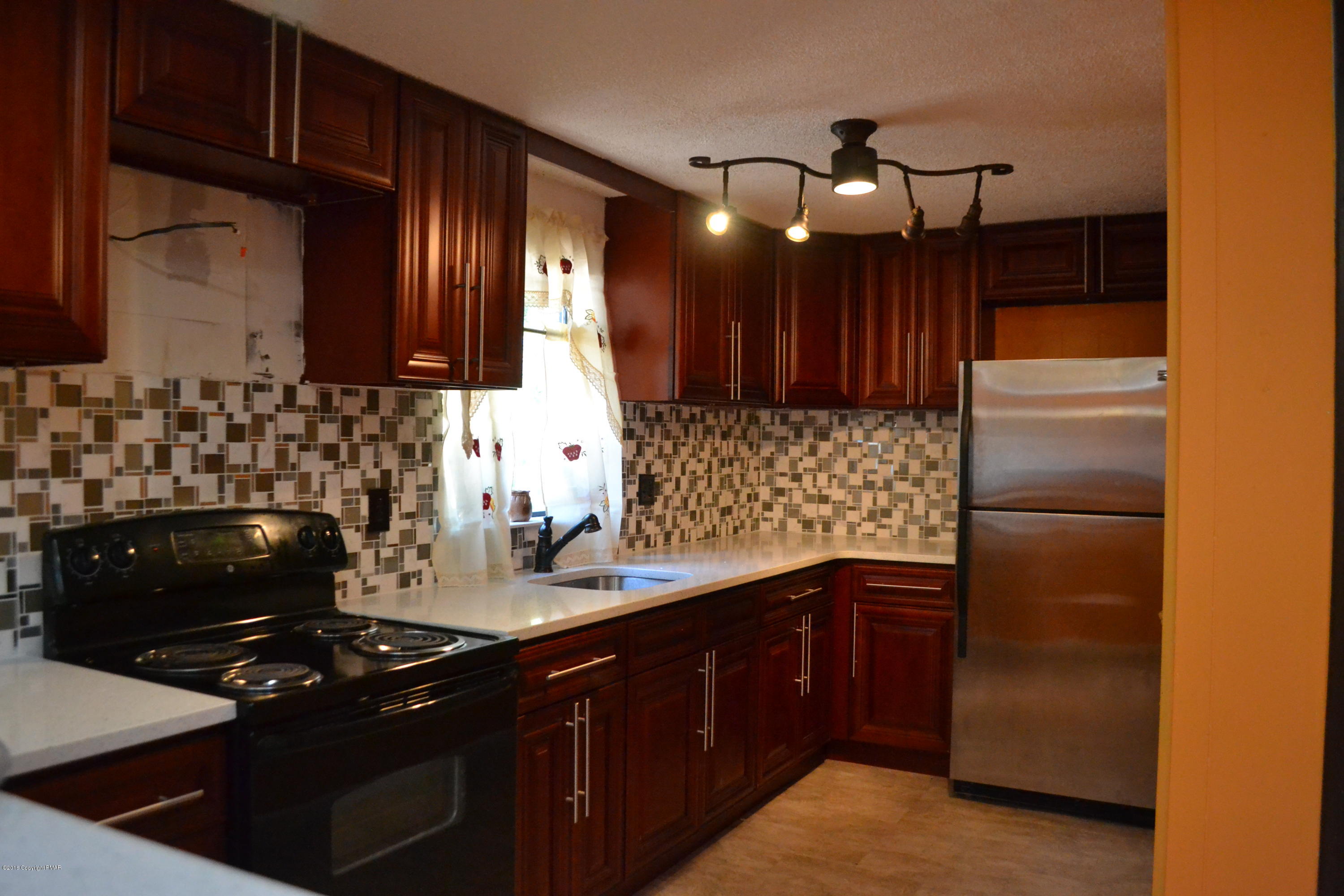 1015 Clover Road Long Pond, PA 18334 - Photo 3 of 35 a kitchen with granite countertop stainless steel appliances and wooden cabinets