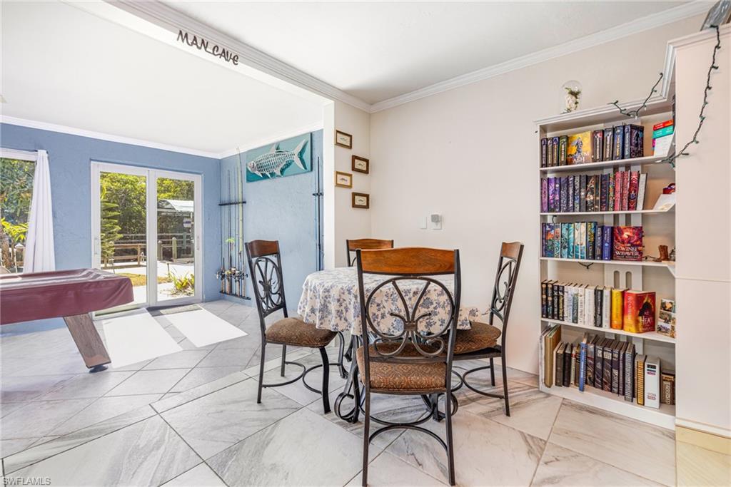 4817-4819 Gary Road Bonita Springs, FL 34134 - Photo 33 of 48 a dining room with furniture and a book shelf