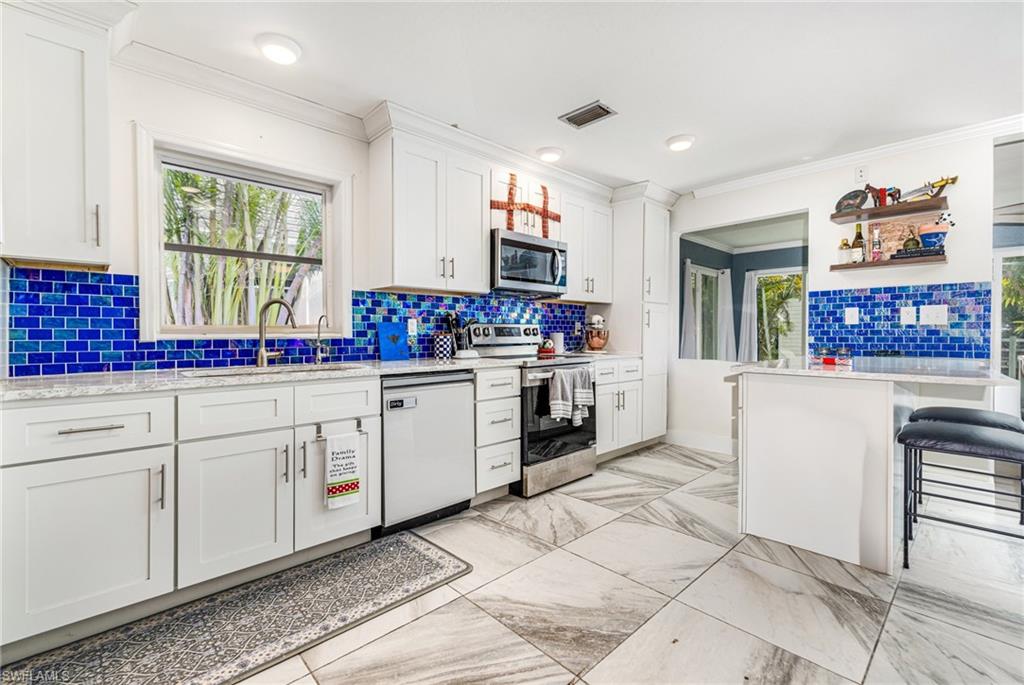 4817-4819 Gary Road Bonita Springs, FL 34134 - Photo 34 of 48 a kitchen with stainless steel appliances granite countertop a stove a sink and a refrigerator