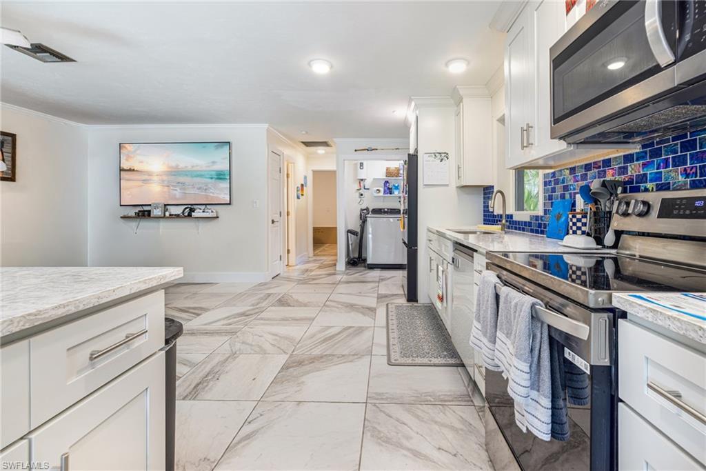 4817-4819 Gary Road Bonita Springs, FL 34134 - Photo 36 of 48 a kitchen with stainless steel appliances granite countertop a sink and cabinets