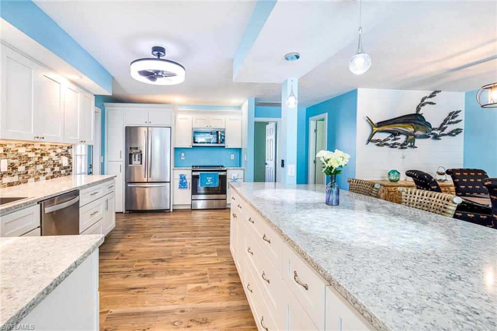 4817-4819 Gary Road Bonita Springs, FL 34134 - Photo 8 of 48 a large kitchen with kitchen island granite countertop a large counter top cabinets and stainless steel appliances