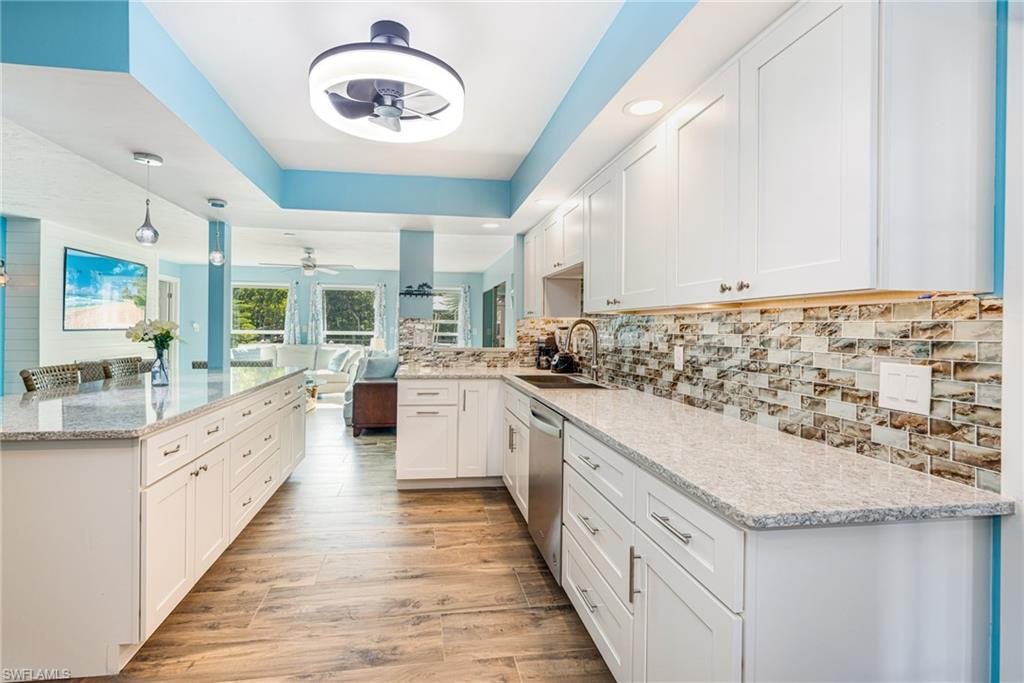 4817-4819 Gary Road Bonita Springs, FL 34134 - Photo 9 of 48 a large kitchen with granite countertop a sink and dishwasher stove a refrigerator with wooden cabinets