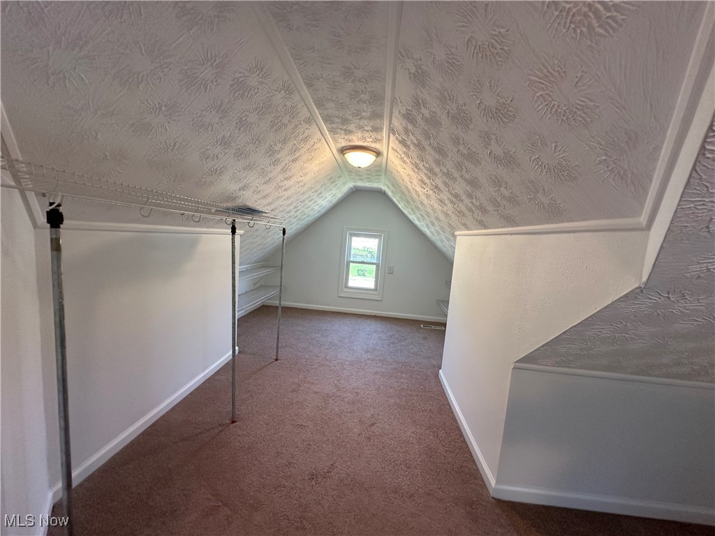 18230 Libby Road Maple Heights, OH 44137 - Photo 28 of 39 Bonus room with lofted ceiling, a textured ceiling, carpet flooring, and baseboards