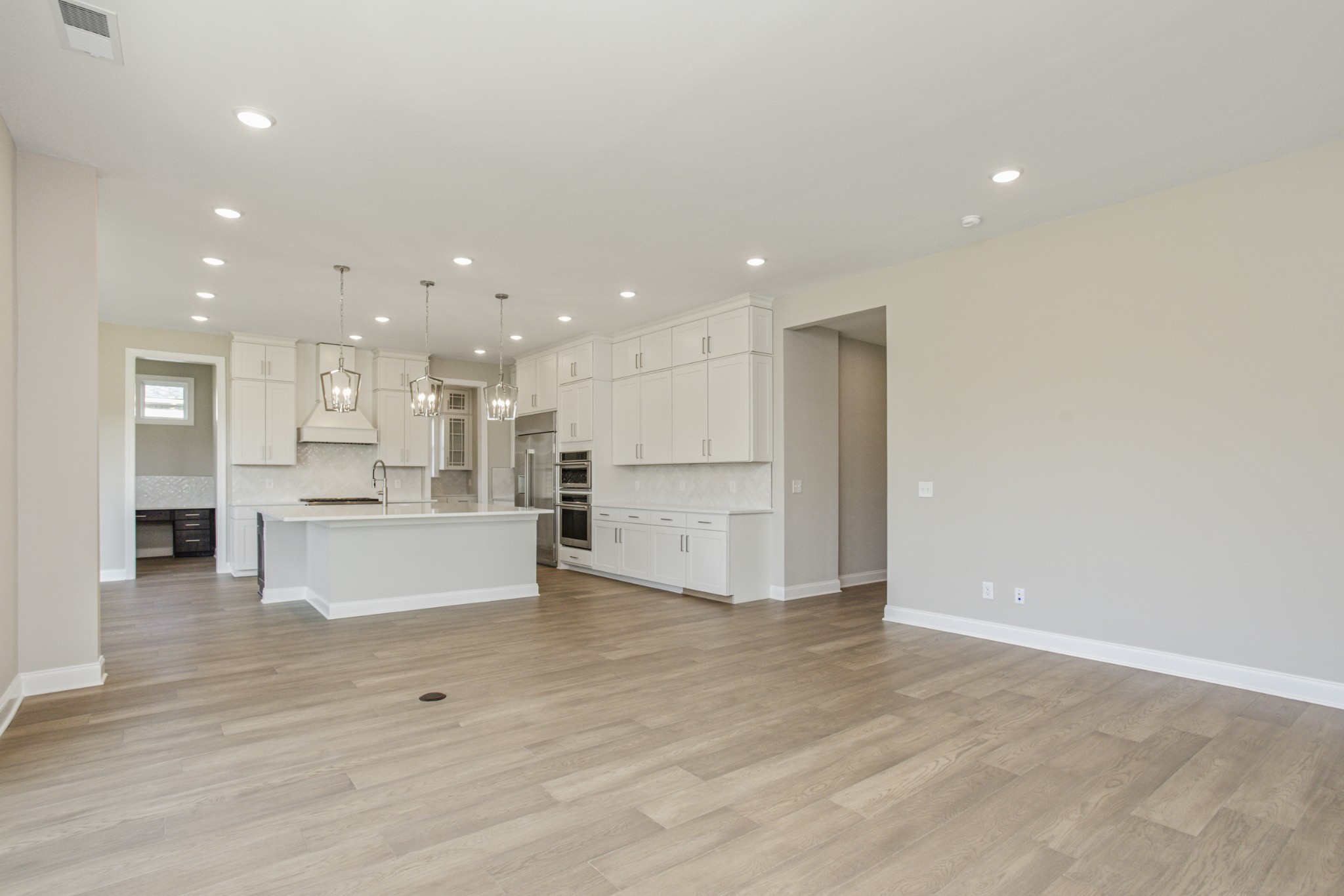 7005 Thunderhead Way Spring Hill, TN 37174 - Photo 21 of 63 a view of kitchen with kitchen island a sink wooden floor and a refrigerator