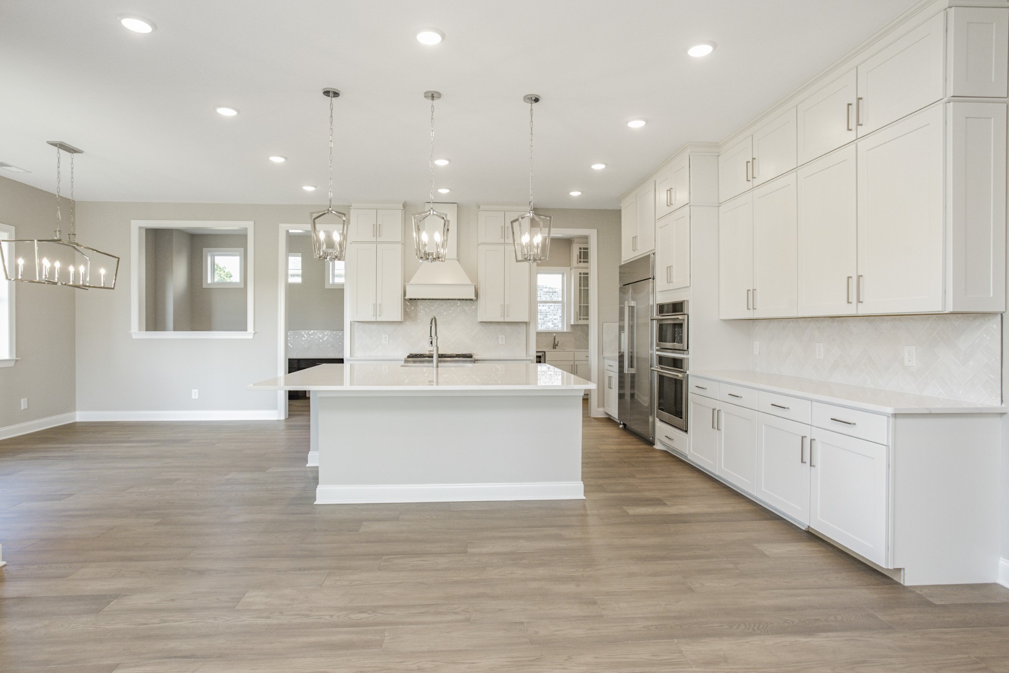 7005 Thunderhead Way Spring Hill, TN 37174 - Photo 24 of 63 a large white kitchen with kitchen island a sink a stove a refrigerator and white cabinets