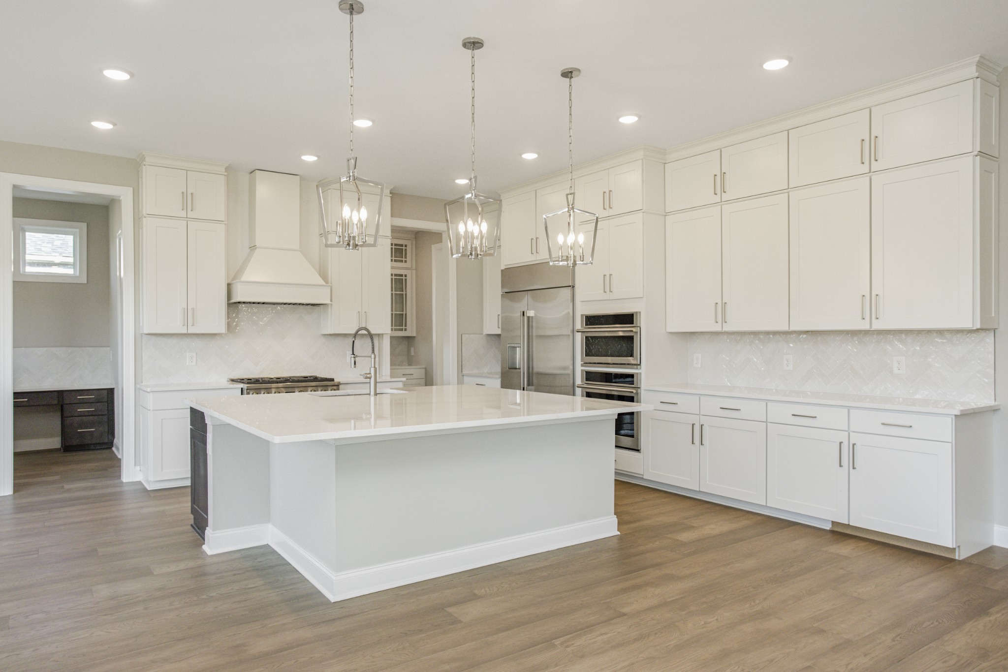 7005 Thunderhead Way Spring Hill, TN 37174 - Photo 25 of 63 a large kitchen with stainless steel appliances granite countertop a stove a sink a refrigerator and white cabinets with wooden floor