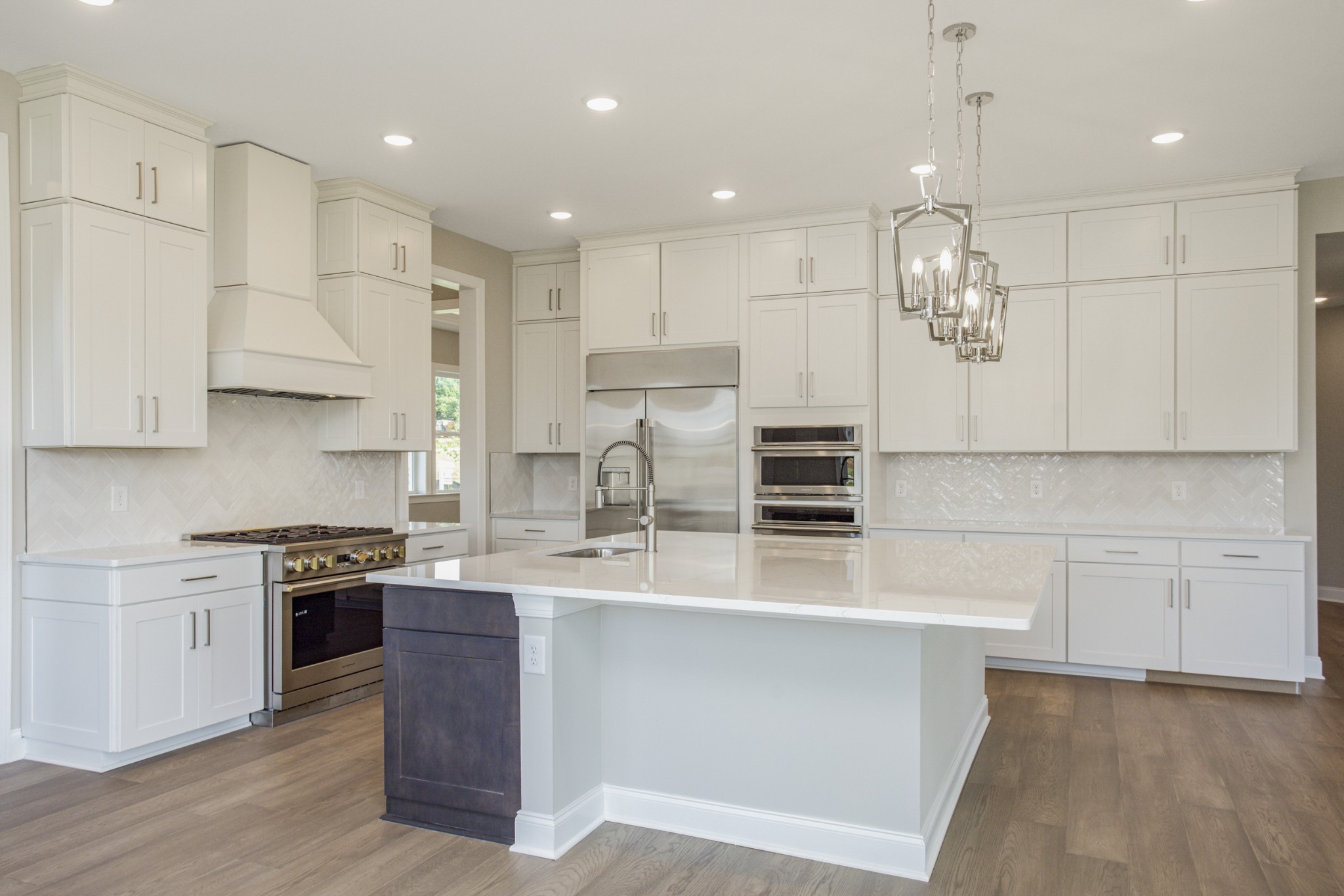 7005 Thunderhead Way Spring Hill, TN 37174 - Photo 26 of 63 a large kitchen with stainless steel appliances kitchen island granite countertop a stove a sink a refrigerator and white cabinets with wooden floor