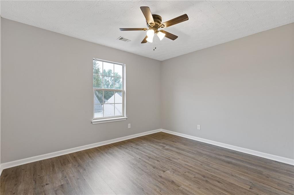 441 Spring Head Court Lawrenceville, GA 30046 - Photo 22 of 27 an empty room with wooden floor and windows