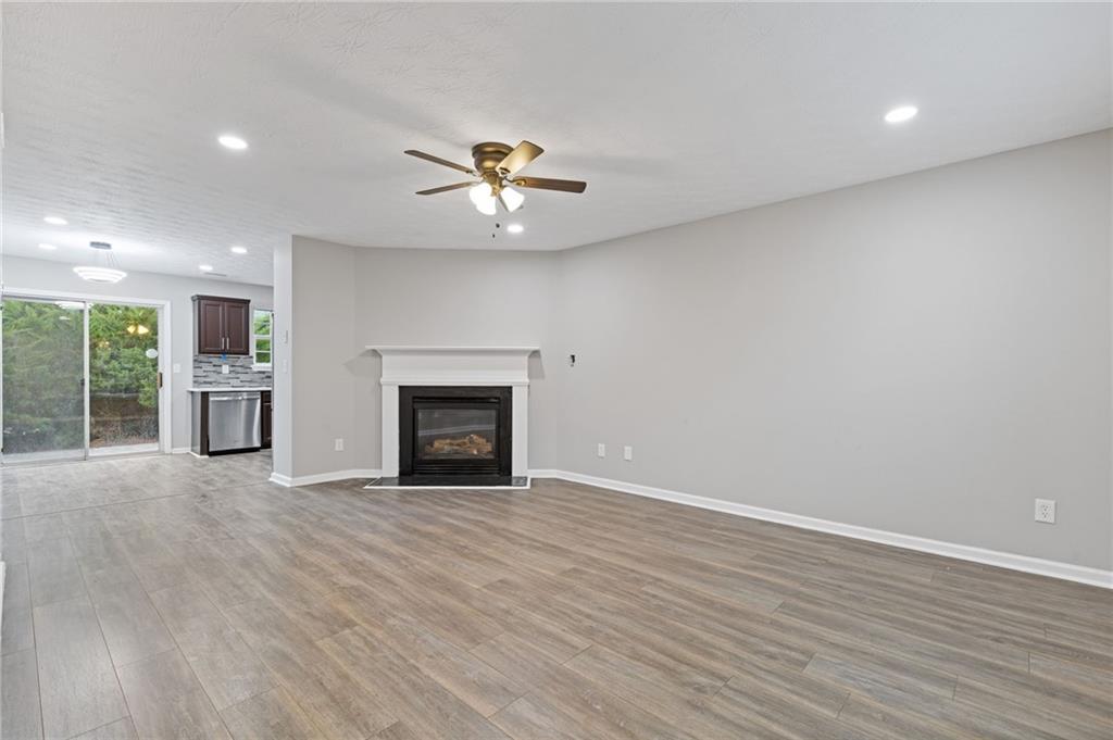 441 Spring Head Court Lawrenceville, GA 30046 - Photo 5 of 27 an empty room with windows fireplace and a kitchen