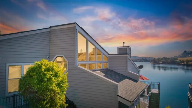 an aerial view of a house with a yard and lake view