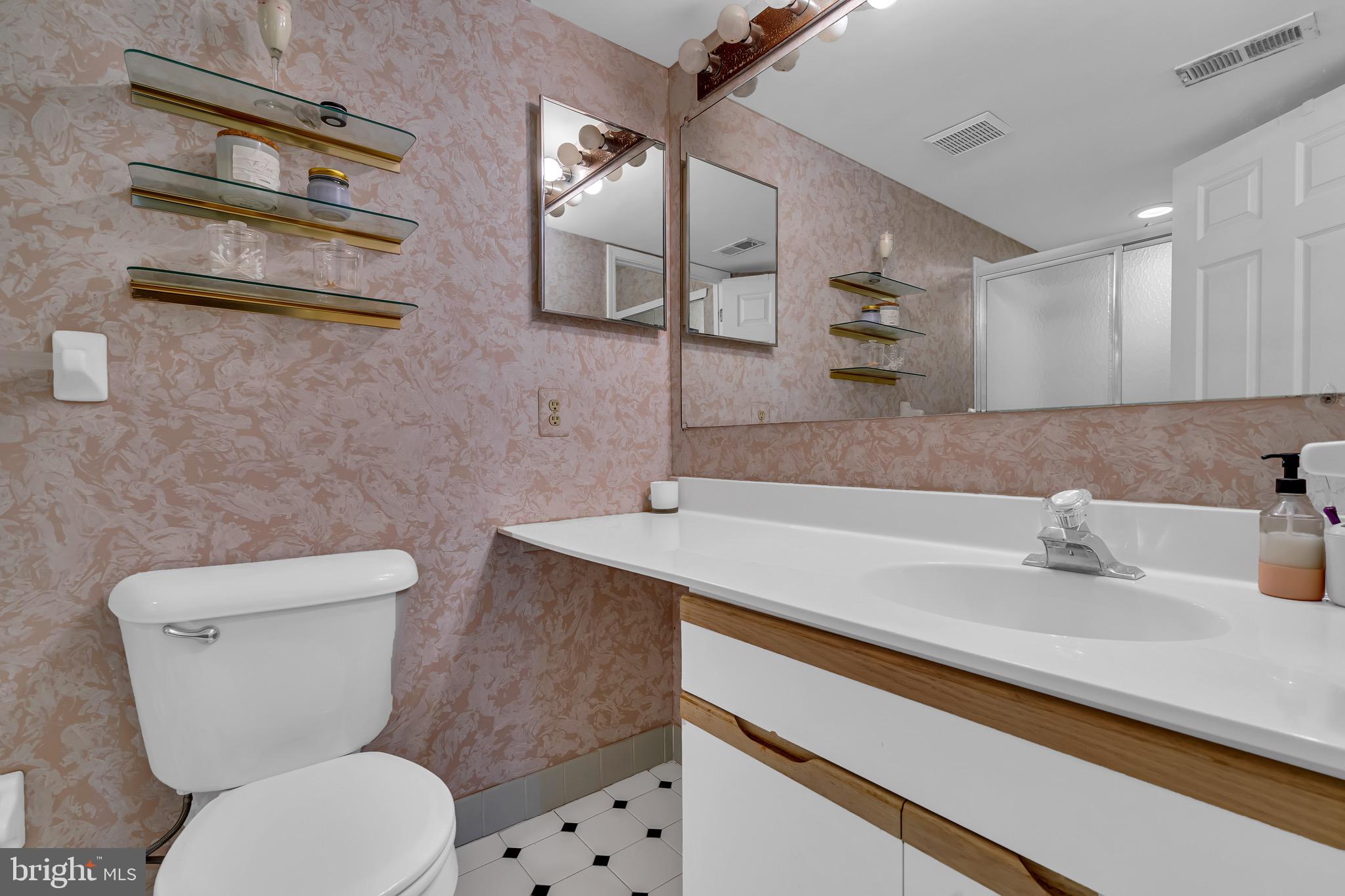 2015 Welsh Road, Unit A22 Philadelphia, PA 19115 - Photo 21 of 27 a bathroom with a sink a toilet and mirror