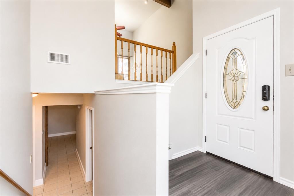 6545 Los Rios Drive Mesquite, TX 75150 - Photo 6 of 9 Entryway featuring a white paneled door with an oval stained-glass insert, dark wood-finish flooring, and light gray wall paint