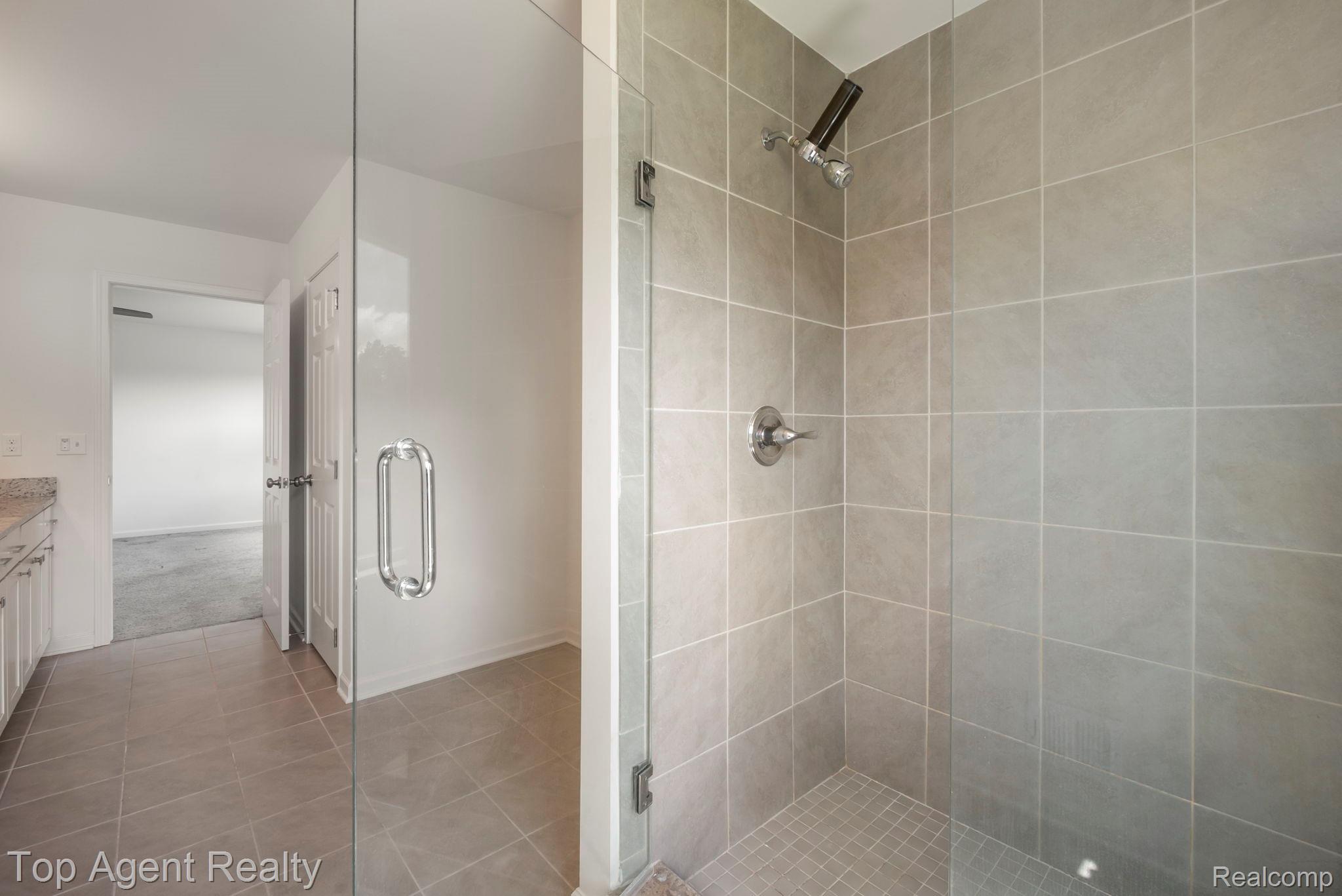 63770 Dequindre Road Washington, MI 48095 - Photo 45 of 61 Glass-enclosed walk-in shower featuring light grey tile walls and a coordinating tile floor