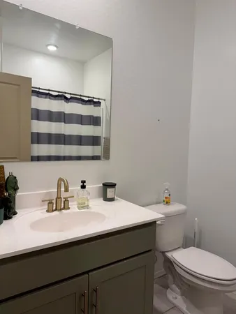 a bathroom with a sink a toilet a mirror and vanity