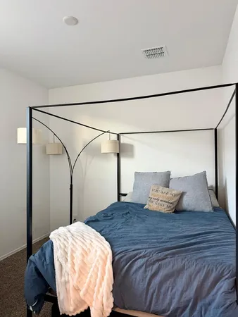 a bedroom with a bed and wooden floor