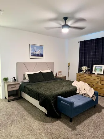 a bedroom with a bed wooden floor and window