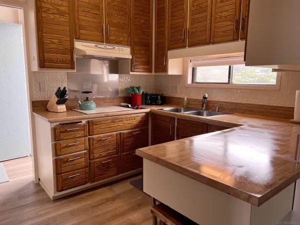 a kitchen with stainless steel appliances granite countertop a sink a stove and wooden cabinets