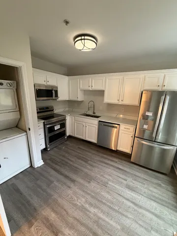 a kitchen with granite countertop a refrigerator and a stove top oven