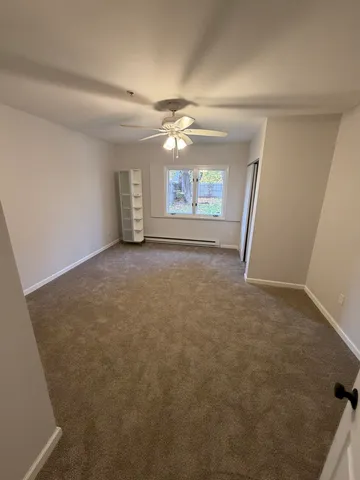 en empty room with windows and ceiling fan