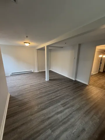 a view of an empty room with wooden floor