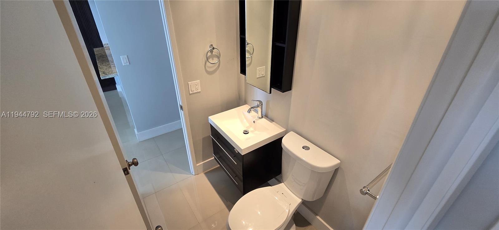 600 Northeast 36th Street, Unit 1509 Miami, FL 33137 - Photo 12 of 21 a bathroom with a toilet sink and mirror