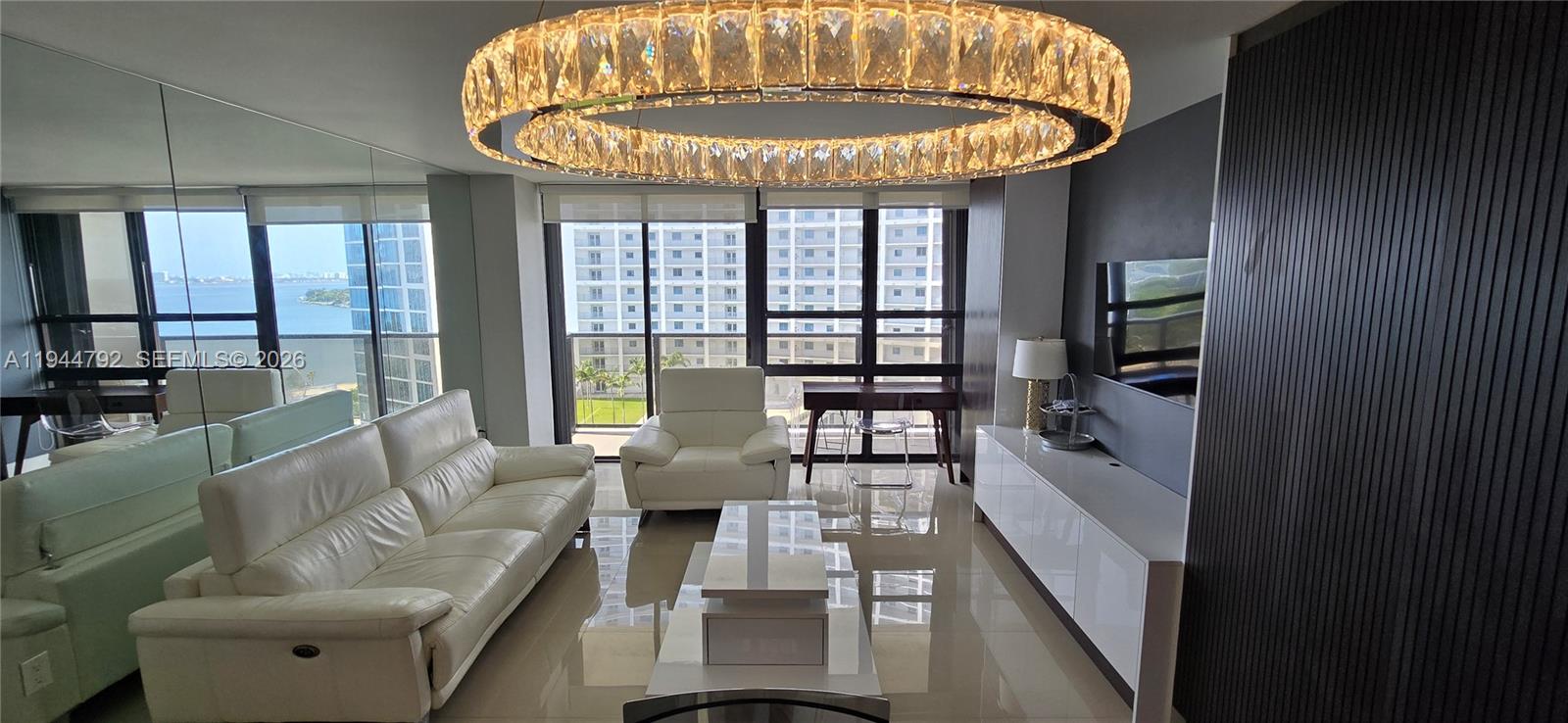 600 Northeast 36th Street, Unit 1509 Miami, FL 33137 - Photo 2 of 21 a living room with furniture and a chandelier