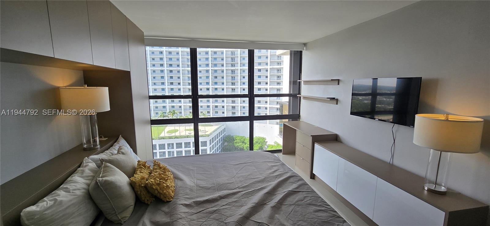 600 Northeast 36th Street, Unit 1509 Miami, FL 33137 - Photo 7 of 21 a bed sitting in a bedroom next to a window