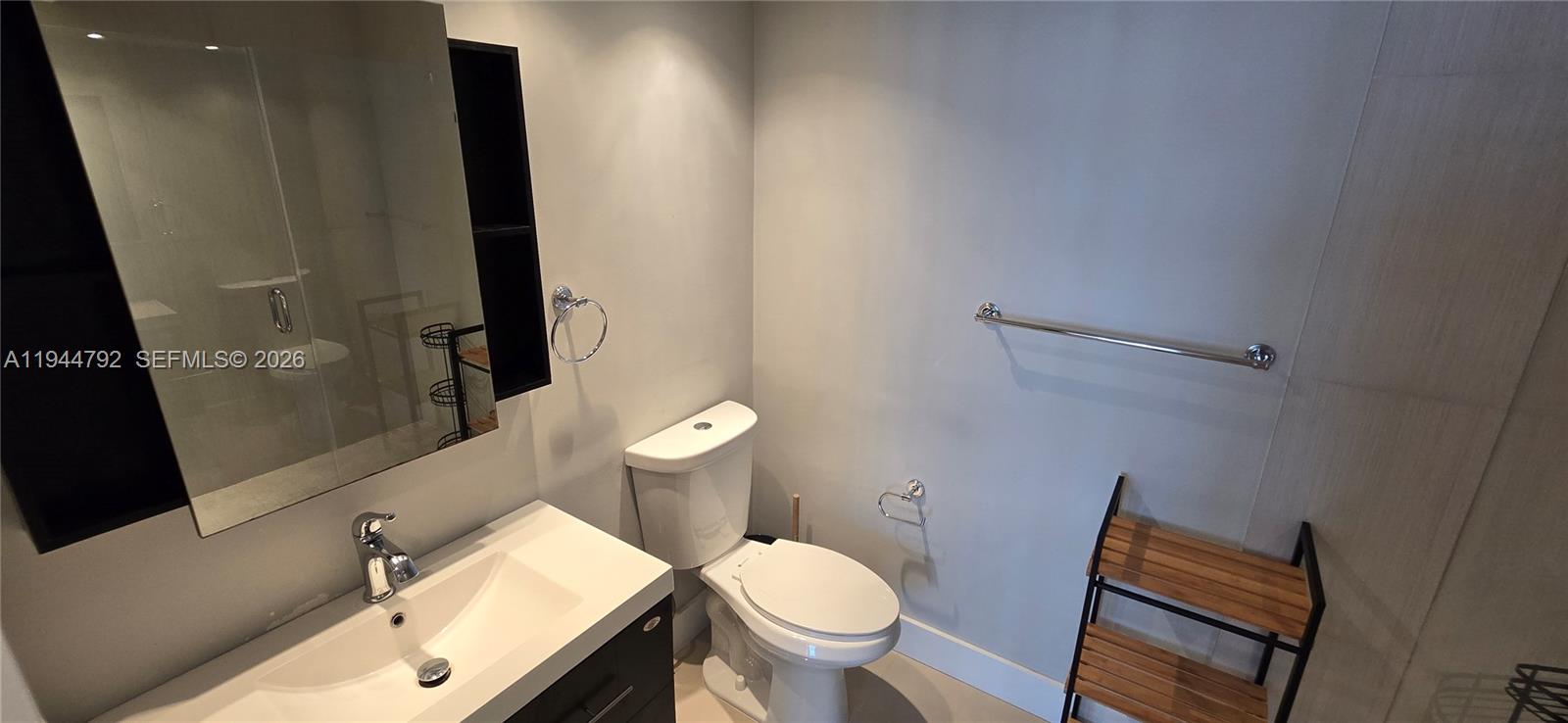 600 Northeast 36th Street, Unit 1509 Miami, FL 33137 - Photo 10 of 21 a white toilet sitting next to a bathroom sink and a mirror