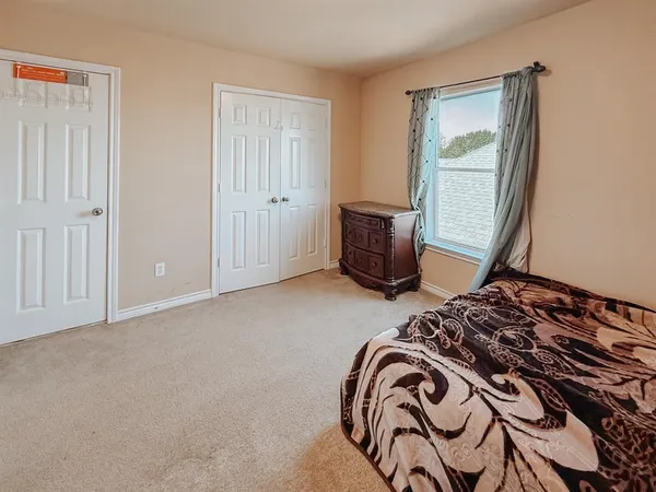 a bedroom with a bed and a window
