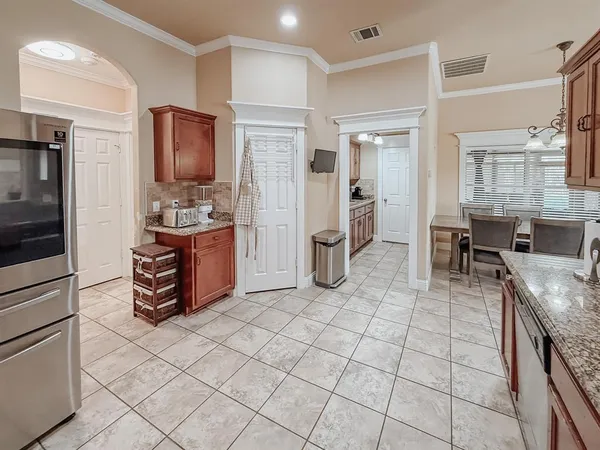 a kitchen with stainless steel appliances kitchen island granite countertop a refrigerator and cabinets