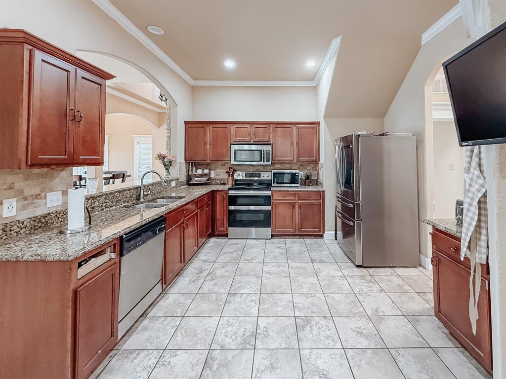 100 Timbershade Drive Red Oak, TX 75154 - Photo 7 of 38 a large kitchen with stainless steel appliances granite countertop a sink stove and refrigerator